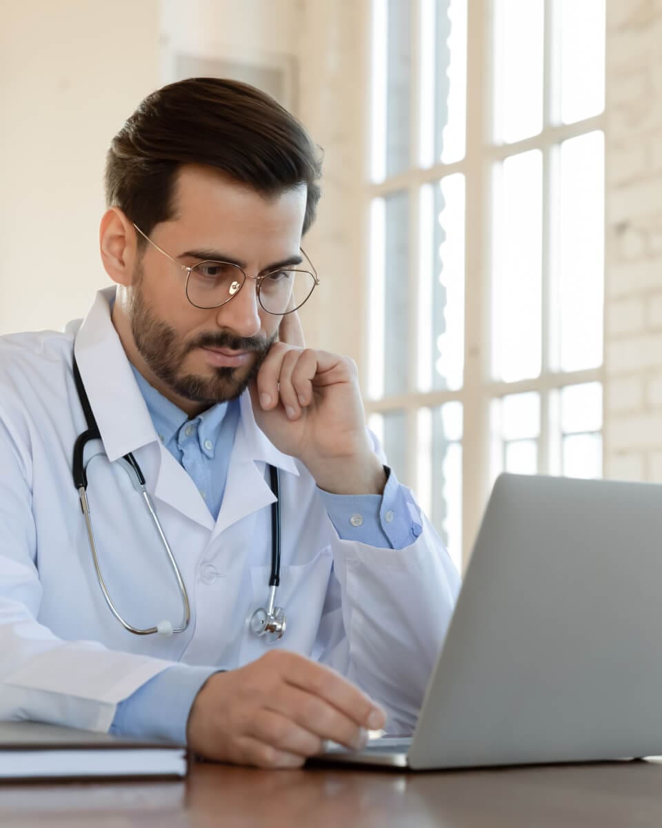 Doctor reviewing information on laptop