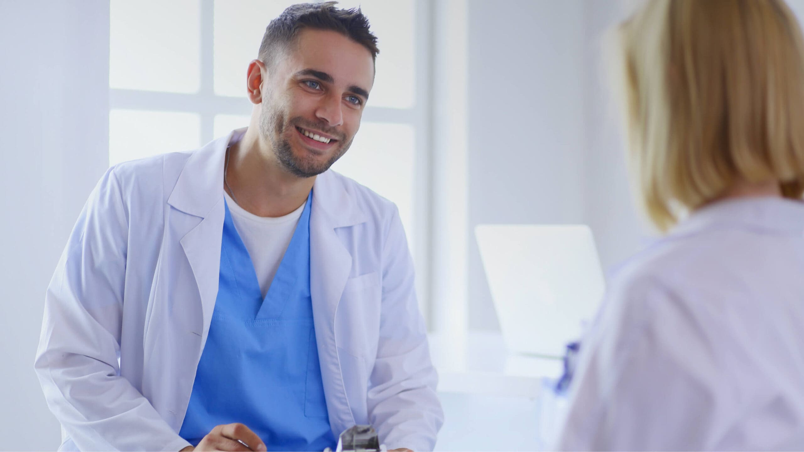 Smiling doctor consulting with patient